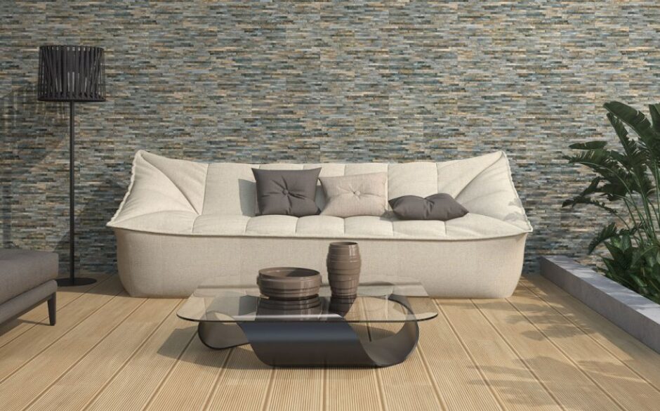 Aspen Magma Rustic Split Face Wall Tiles with a large cream sofa sat in front and grey furniture accents