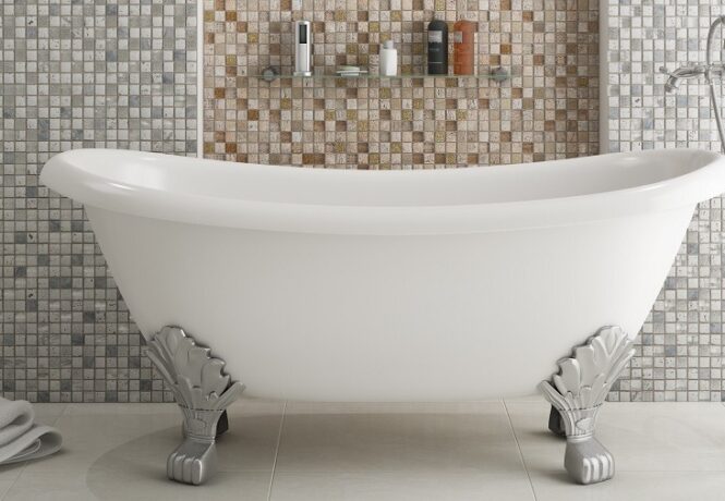 A beautiful vintage roll top style of bath with silver claw legs. In the background is a wall with glamorous mosaic tiles.