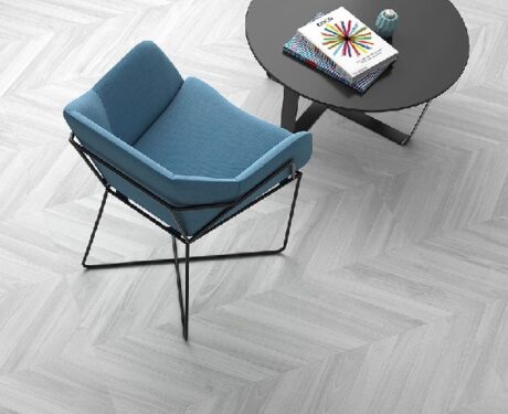 Ebony Grey Herringbone Tiles in a room setting with a blue armchair and small round black table