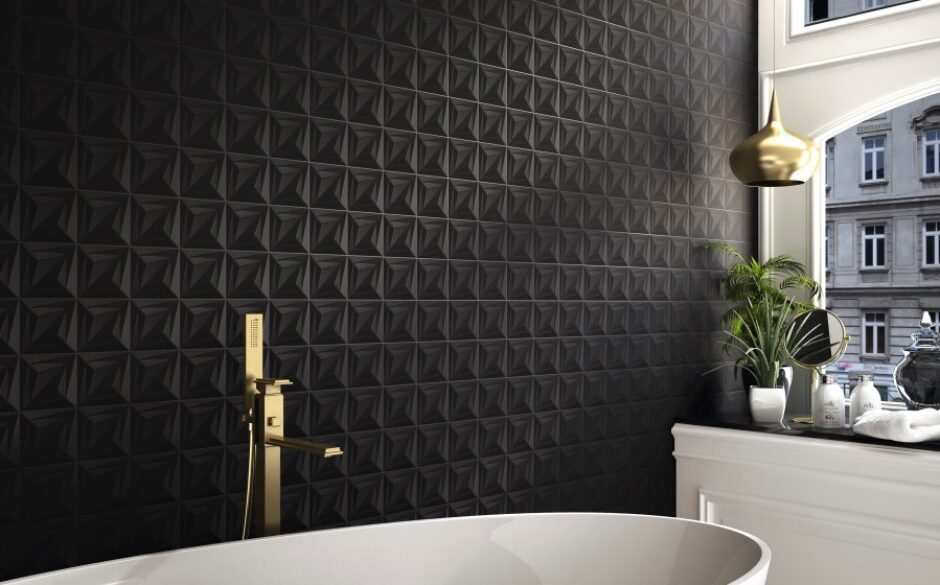 Image of a textured black wall using Delta Black Triangle Tile Pattern. A gold showerhead sits over the white bathtub
