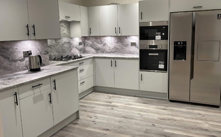 Room shot of Jean's Grey Kitchen after renovation showing grey vinyl flooring and marble splashback above the counters