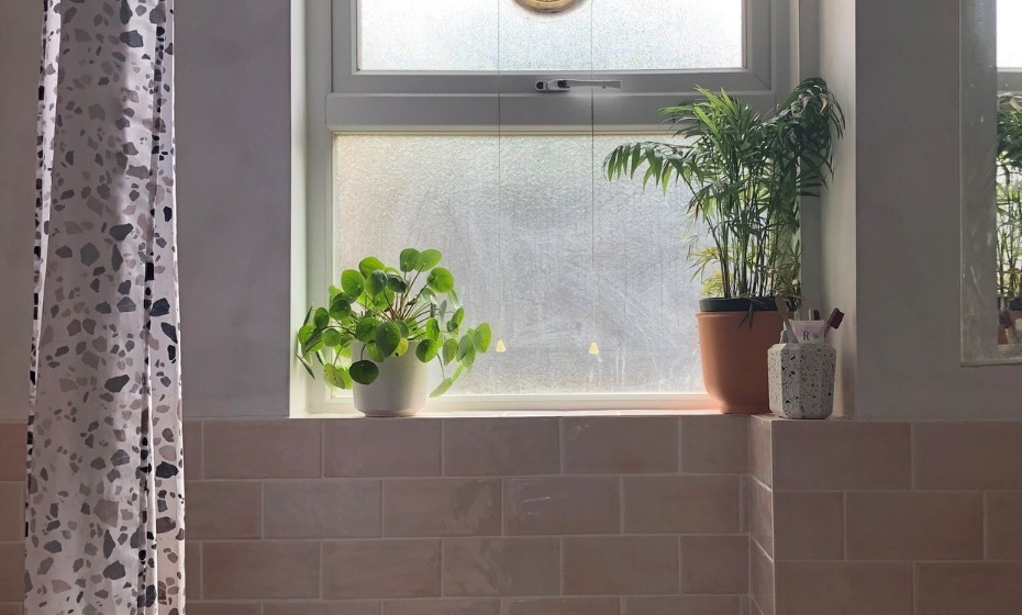 Gamma Pink Bathroom tiles with plants sat atop the windowsill to add a pop of green,