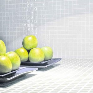 White mosaic tiles in a kitchen with plates of apples